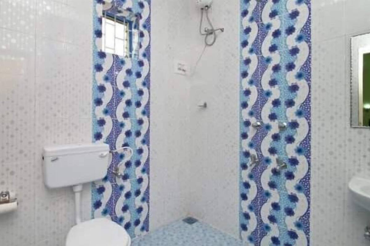 A bathroom with a toilet, bidet, and shower area.