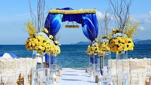An outdoor wedding setup with a blue arch and yellow floral arrangements. - Da Mei Sha Yacht Club Resort (Shenzhen)
