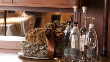 A wooden cabinet with glass doors, containing bottles and a decorative item.