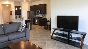 Un appartement moderne comprenant un salon, une cuisine et un coin repas.