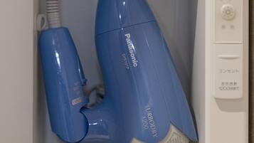 A hair dryer and a smaller appliance in a white cabinet, with Japanese text and a control panel.