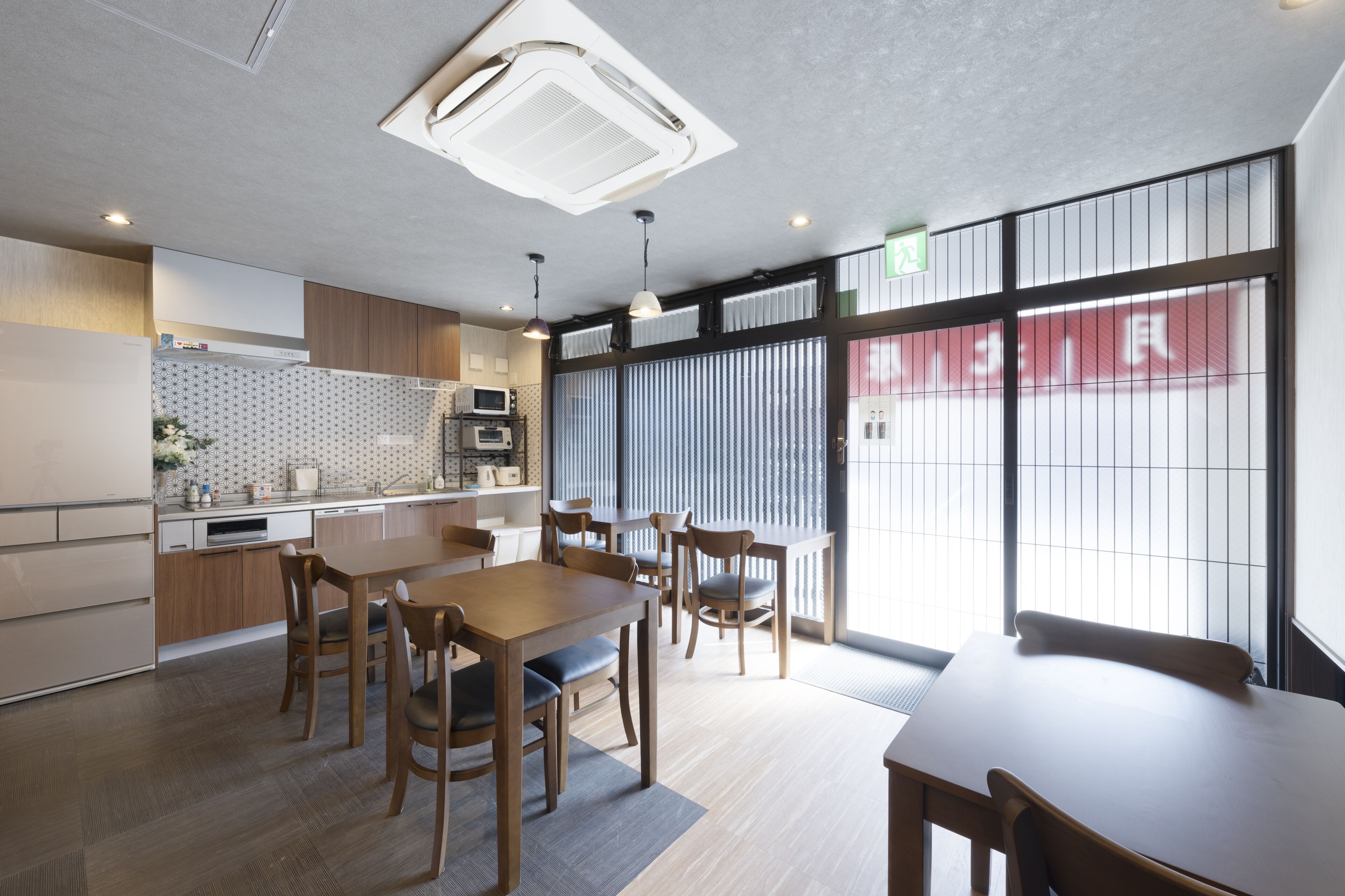 A modern kitchen with wooden cabinets, a central island, and a dining area with wooden tables and chairs.