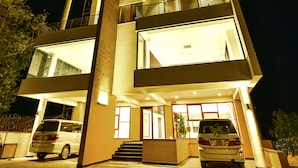 A modern hotel with multiple floors, large windows, and a well-lit entrance. - K Hotels (Entebbe)