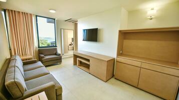 Een moderne woonkamer met een bank, een televisie en een houten kast.
