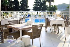 A restaurant with outdoor seating overlooking a pool and a scenic view. - Incekum Su Hotel - All Inclusive (Alanya)