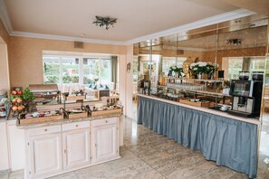 Una cocina con encimera de mármol, estación de café y vistas al exterior.
