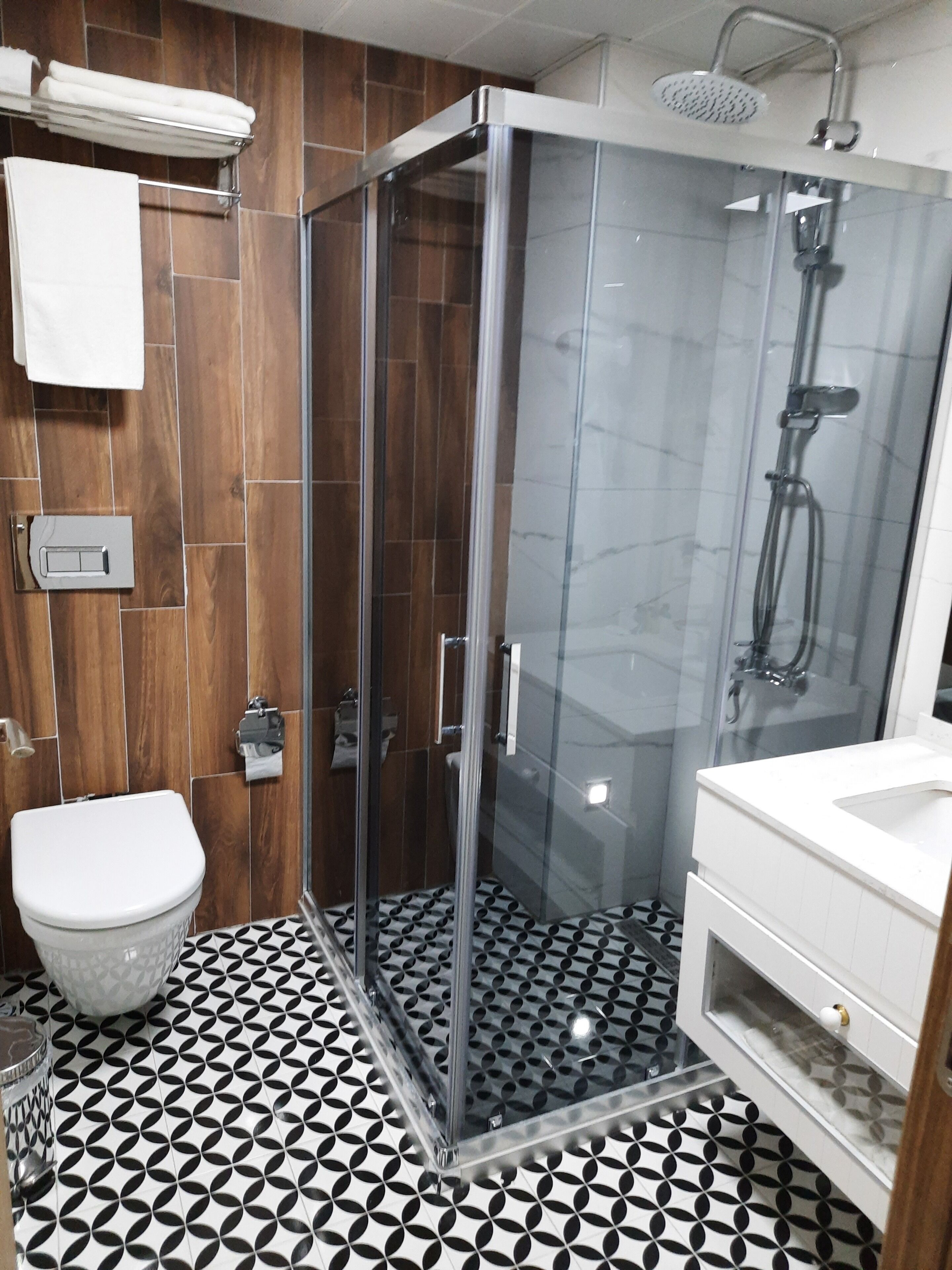 Un baño con ducha envuelta en vidrio, inodoro y lavabo.