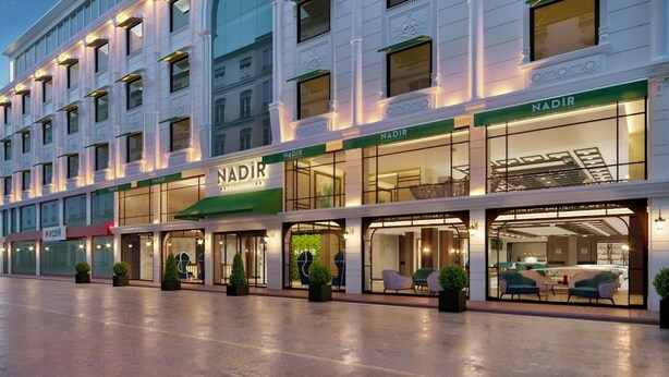 A hotel with multiple Nadir brand stores on the ground floor, featuring large glass windows and a modern design. - Nadir Business Hotel (Karaman)