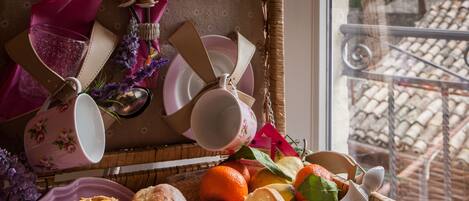 A wicker basket filled with pastries, fruits, and a teapot.