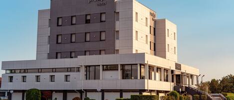 Un moderno edificio de hotel con techo plano, múltiples ventanas y un letrero que dice "prealpi hotel".