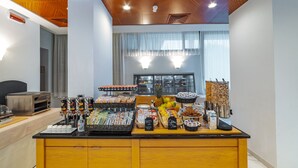 A breakfast bar with various food items, including fruits, cereals, and beverages. - Prealpi Hotel (San Vendemiano)