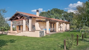 A two-story house with a red-tiled roof, a balcony, and a covered patio area. - Awesome home in Capodimonte (VT) (Capodimonte (VT))