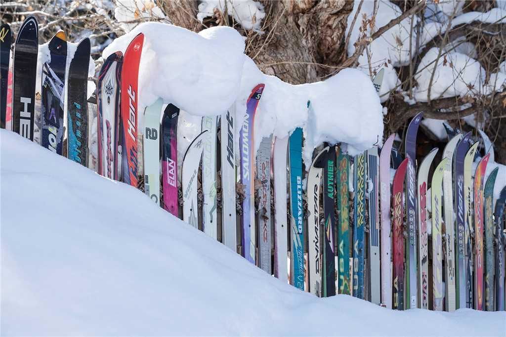 A row of skis leaning against a snow-covered slope.