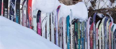 A row of skis leaning against a snow-covered slope.