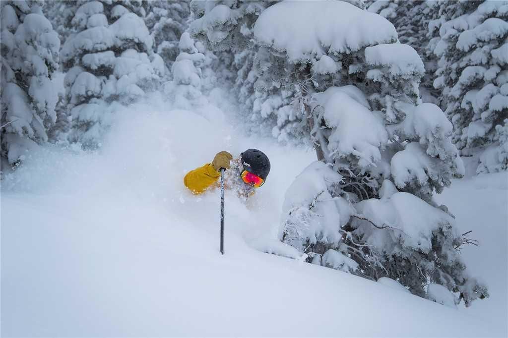 A snowy landscape with a person skiing.