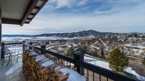 A balcony with a view of a snowy landscape and a town below. - 410 Storm Meadows Club C Apartment 2 (Steamboat Springs)