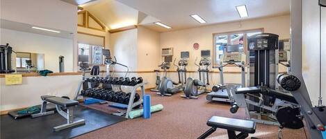 A gym with various exercise equipment, including dumbbells, treadmills, and weight machines.