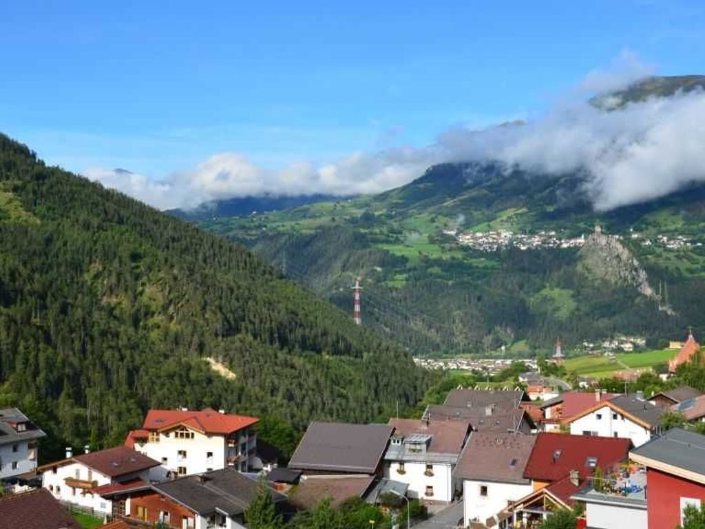 A mountainous village with houses and a lighthouse.