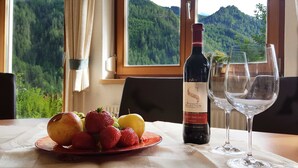A table with a bottle of wine, two glasses, and a plate of fruit. - Apart Franzi Top 1 - Apart Franziska (Kauns)