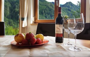 A table with a bottle of wine, two glasses, and a plate of fruit. - Apart Franzi Top 1 - Apart Franziska (Kauns)