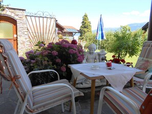 A patio with a table, chairs, and a statue.