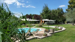 A backyard with a swimming pool, outdoor furniture, and a covered seating area. - Saturnia Glamping - Seme di Carota (Manciano)