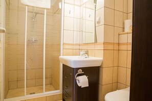 A bathroom with a shower, a sink, and a toilet.