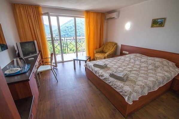 Driepersoonskamer | Luxe beddengoed, een minibar, een kluis op de kamer, een bureau