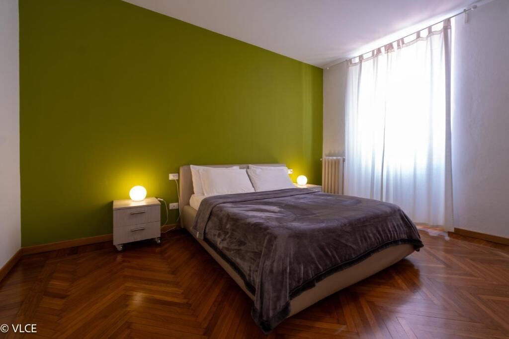 Ein Schlafzimmer mit einem Bett, Nachttischen und einem Beistelltisch.