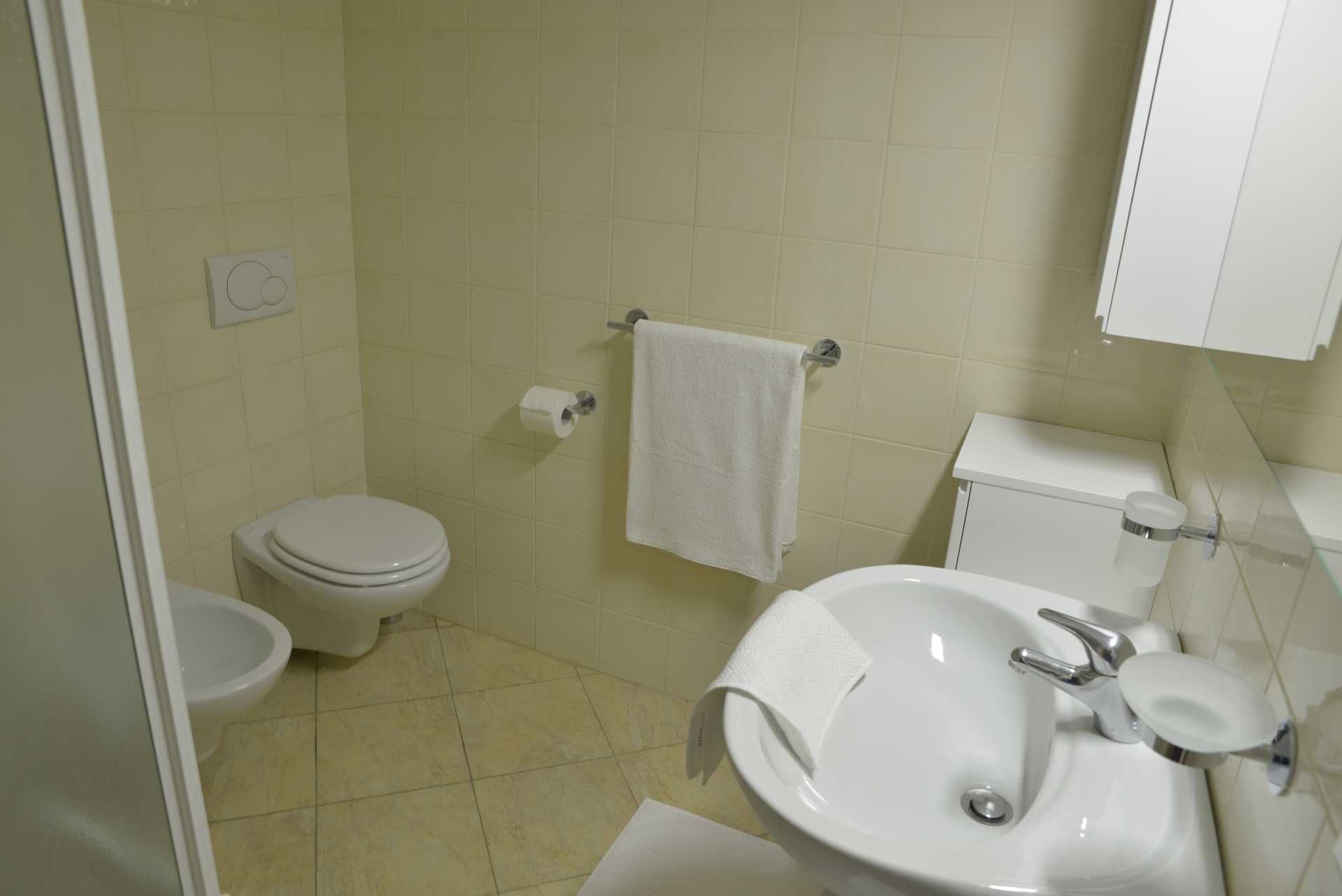 A bathroom with a toilet, bidet, and sink.