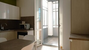 Eine moderne Küche mit Mikrowelle, Spüle und einem Essbereich mit Tisch und Stühlen.