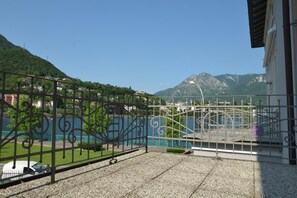 A balcony with a view of a lake and mountains.