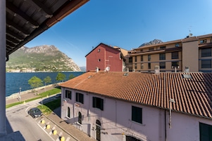 Un edificio con techo rojo, vista a un lago y montañas al fondo.