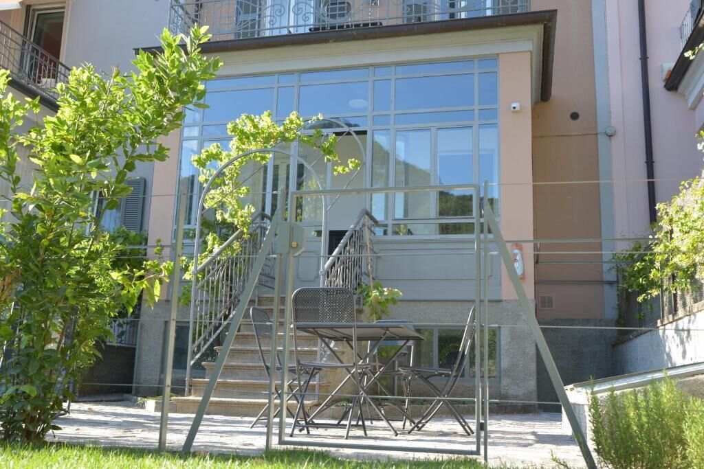 Un edificio con facciata in vetro, scala in metallo e area salotto all'aperto.