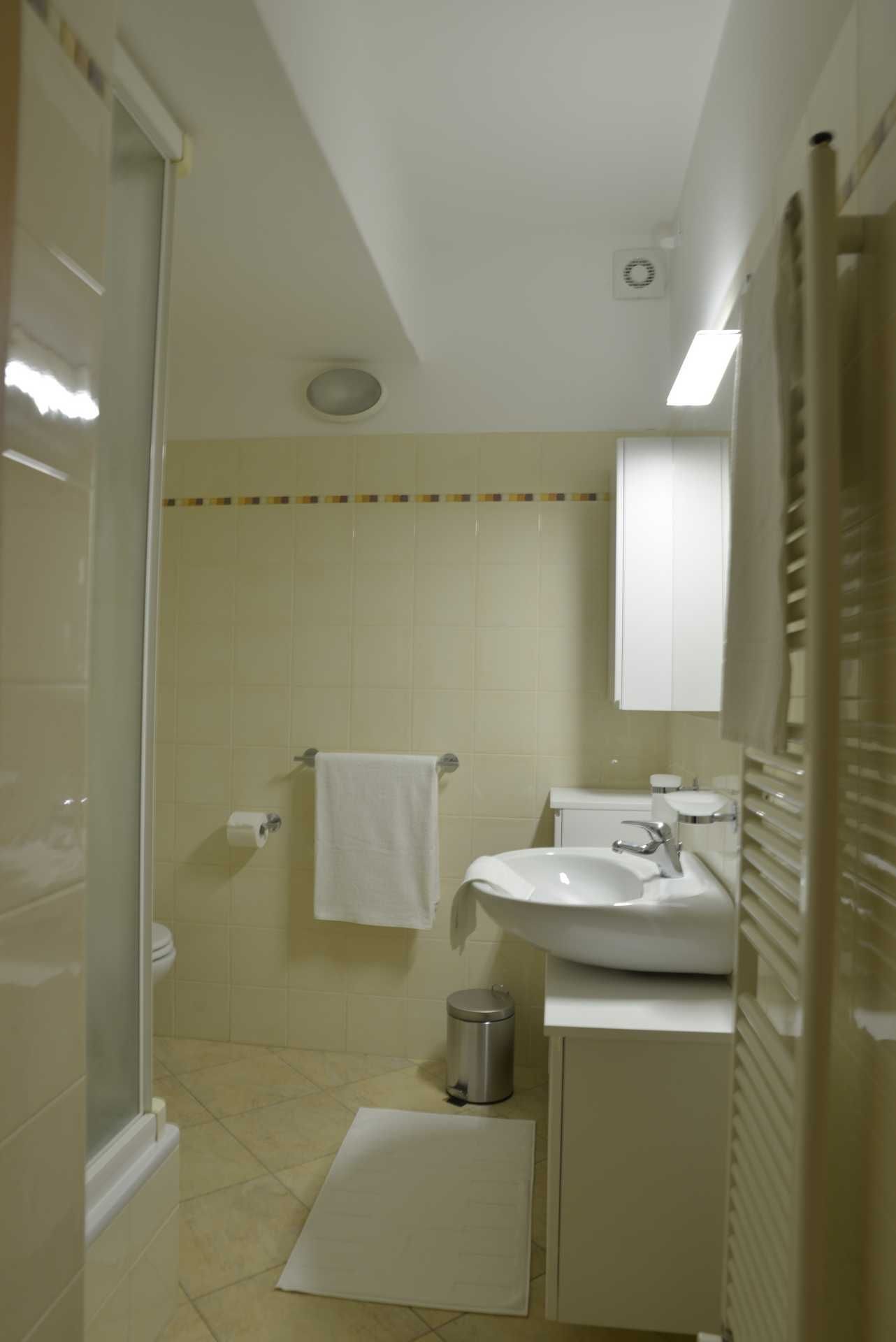 A small, compact bathroom with a toilet, sink, and shower area.