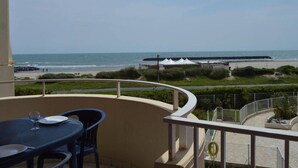 Un balcon avec vue sur la plage et l’océan.