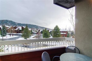 A balcony with a view of a snowy town and mountains.