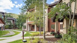 A residential area with modern houses, a curved driveway, and well-maintained landscaping. - 3306 Champagne Lodge, Trappeur's Crossing Apartment 2 (Steamboat Springs)