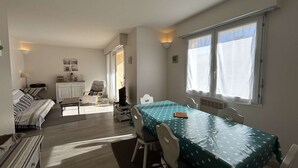 Een ruimtelijk ingerichte leefruimte met een eethoek, kitchenette en een gezellige zithoek.