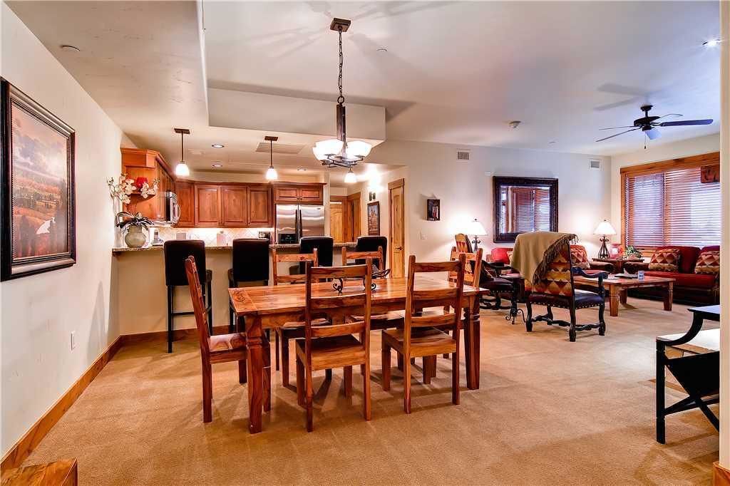 Un amplio espacio de sala con una mesa de comedor y sillas, un sofá y un ventilador de techo.