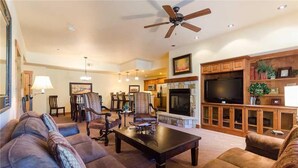 A spacious living room with a fireplace, comfortable seating, and a television. - 5109 Emerald Lodge, Trappeur's Crossing Apartment 4 (Steamboat Springs)