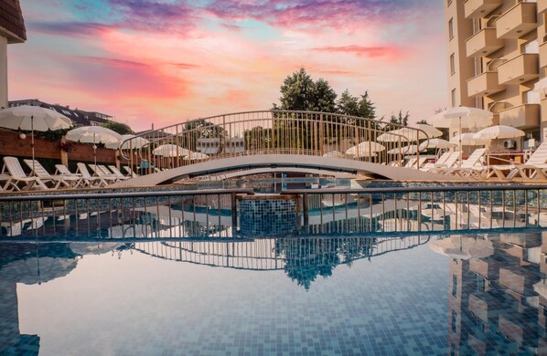 Una piscina techada, 2 piscinas al aire libre, sombrillas