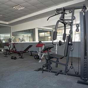 A gym with exercise equipment, a bench, and a mirror. - Hotel Aurora - All Inclusive (Varna)