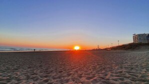 A beach at sunset with a clear sky, a sandy shore, and a building in the background. - Seafront 3-Room Apartment with Balcony, Pool, and Private Parking - Sleeps 4 (Saint-Jean-de-Monts)