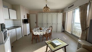 Une cuisine compacte avec un coin repas, une petite table avec un livre et un canapé.