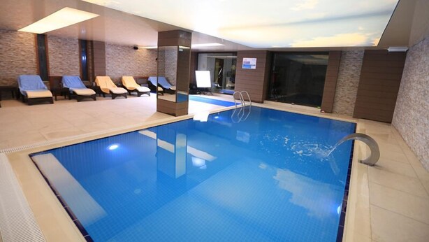 An indoor swimming pool with a clear view of the ceiling and a tiled floor. - Bal Otel (Tirebolu)