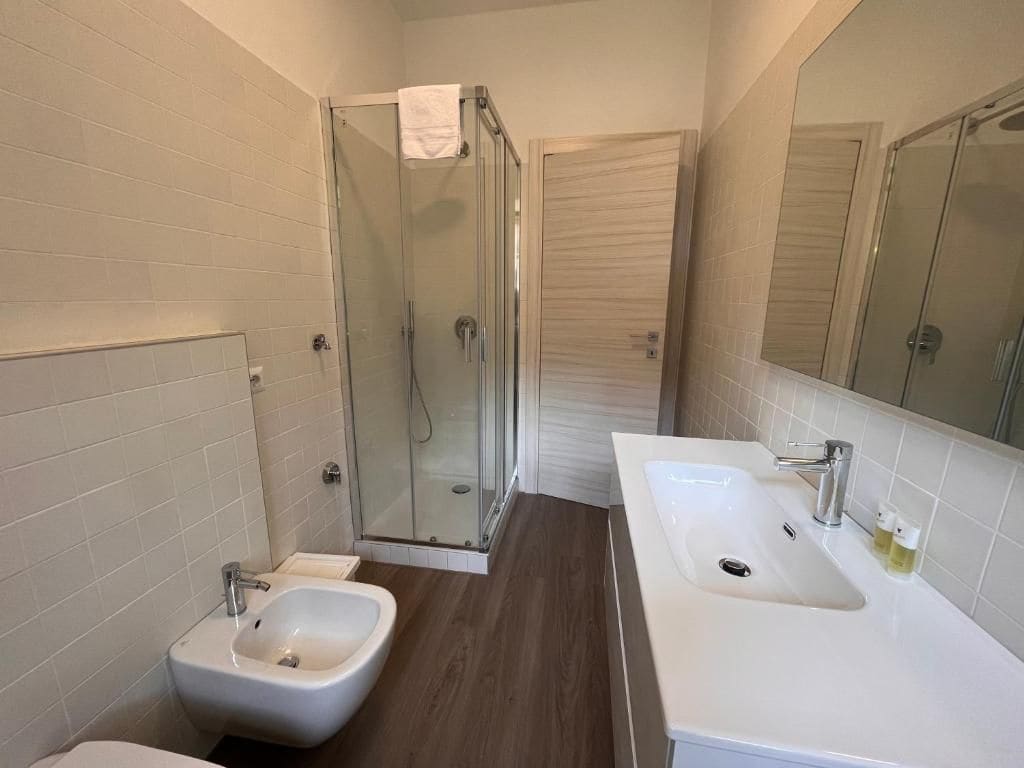Une salle de bain moderne équipée d’une douche, de deux lavabos et d’un bidet.
