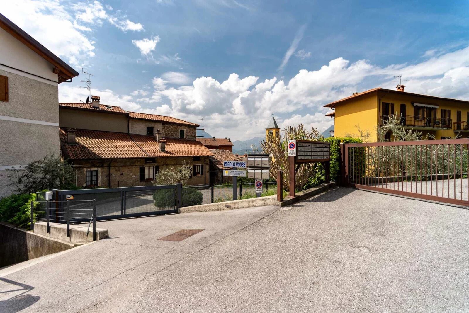 Una propiedad amurallada con un letrero que dice "REGOL HOUSE" y un buzón.
