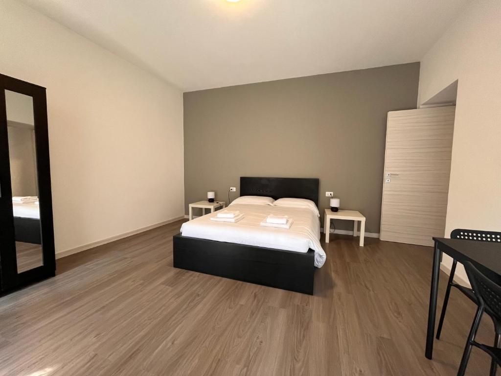 A bedroom with a bed, bedside tables, a wardrobe, and a mirror.