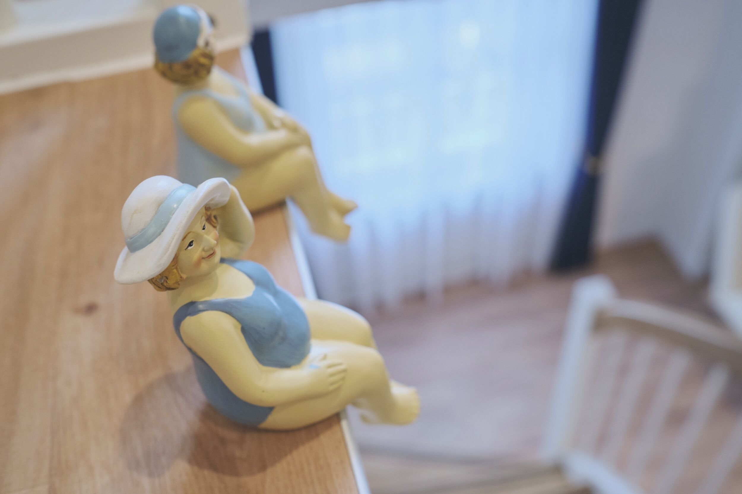 Duas pequenas figuras sobre uma superfície de madeira.